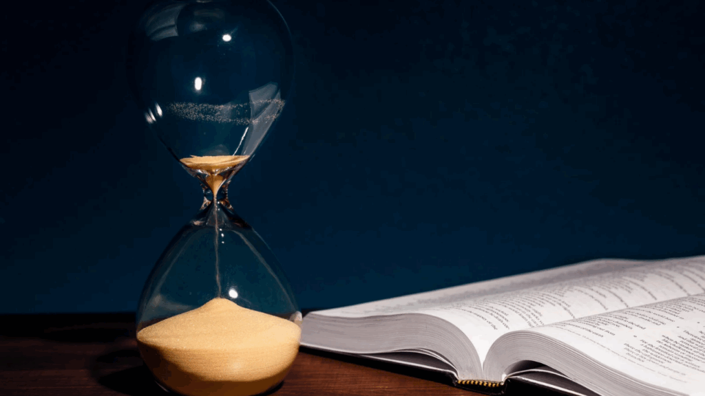 Uma ampulheta mostrando o tempo e uma bíblia indicando que é Nela que está tudo sobre o fim dos tempos 